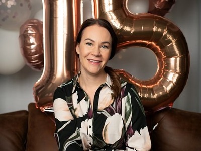Nainen istuu sohvalla yrityksensä 15-vuotisjuhlassa.